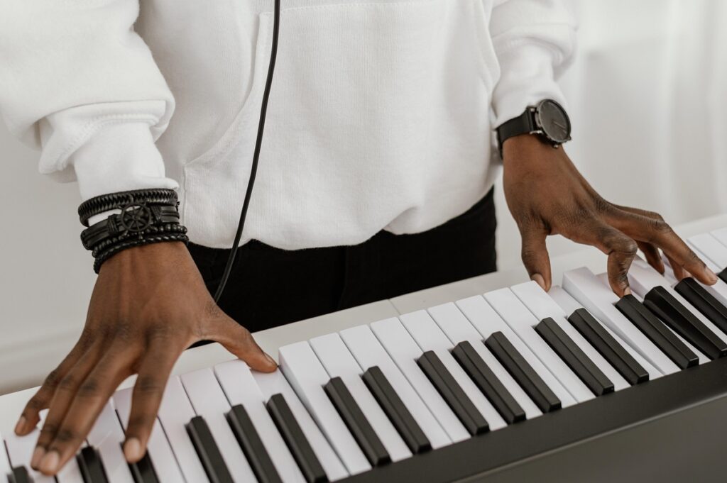 Diferenças essenciais entre teclados e pianos digitais 1 Alto ângulo de musico tocando teclado
